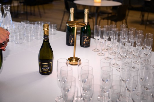 Photo of bottles of Cava and a buffet table with glasses.