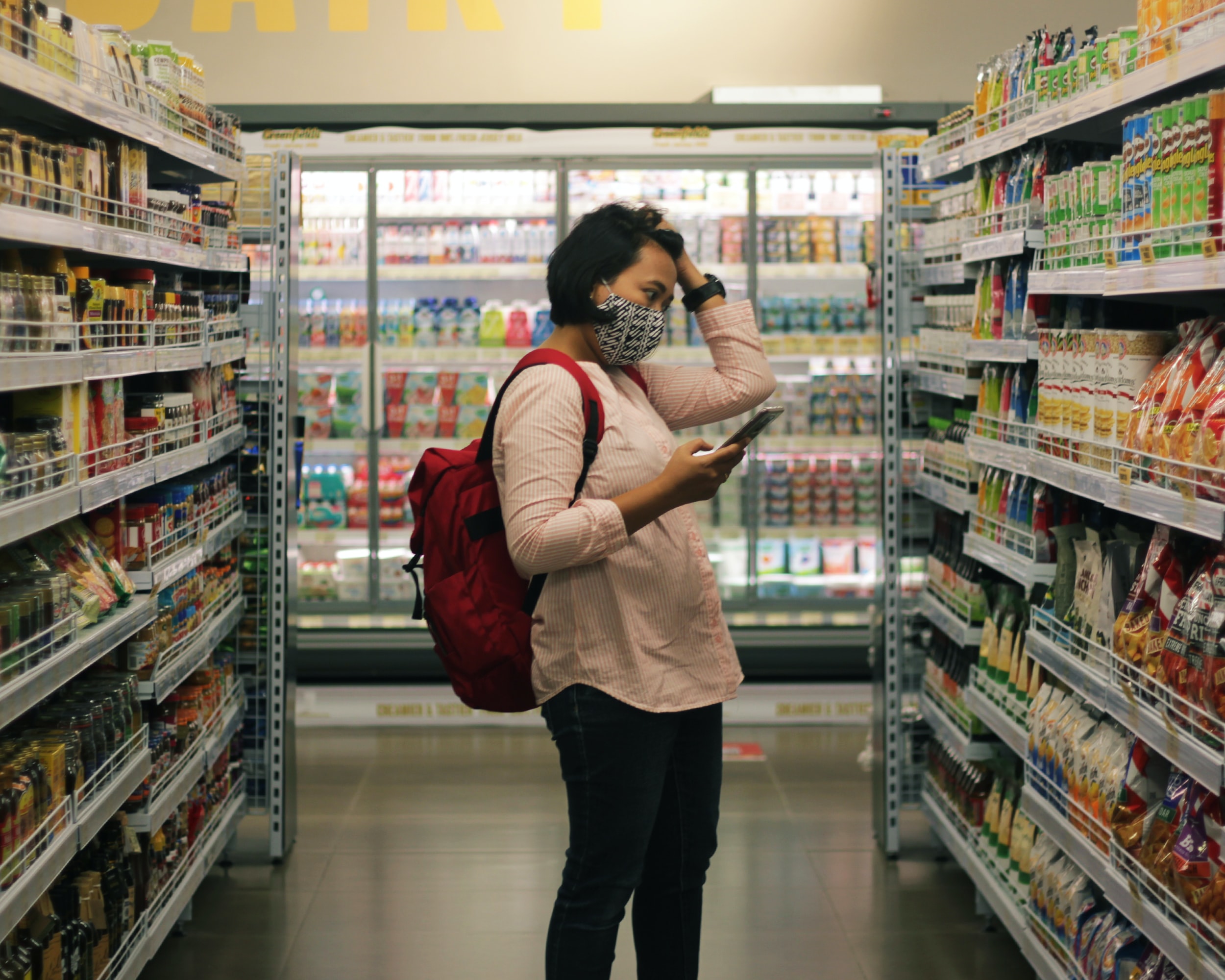 Photo of a person standing in the aisle of a supermarket 