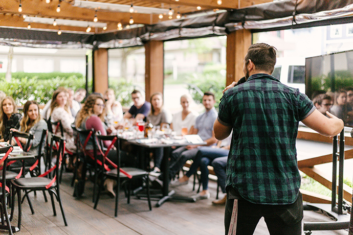 a speaker in front of of a small crowd in a café