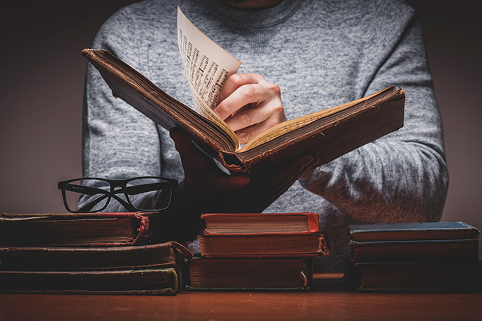 Photo of a person opening an old book